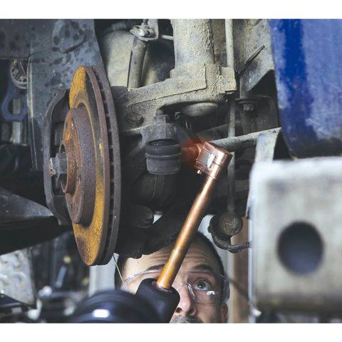 Technician using GYS Advanced Powerduction Induction Heater + Coolant U56992 to heat a rusted bolt on a vehicle suspension. Ideal for safe, fast metal heating in automotive repair.