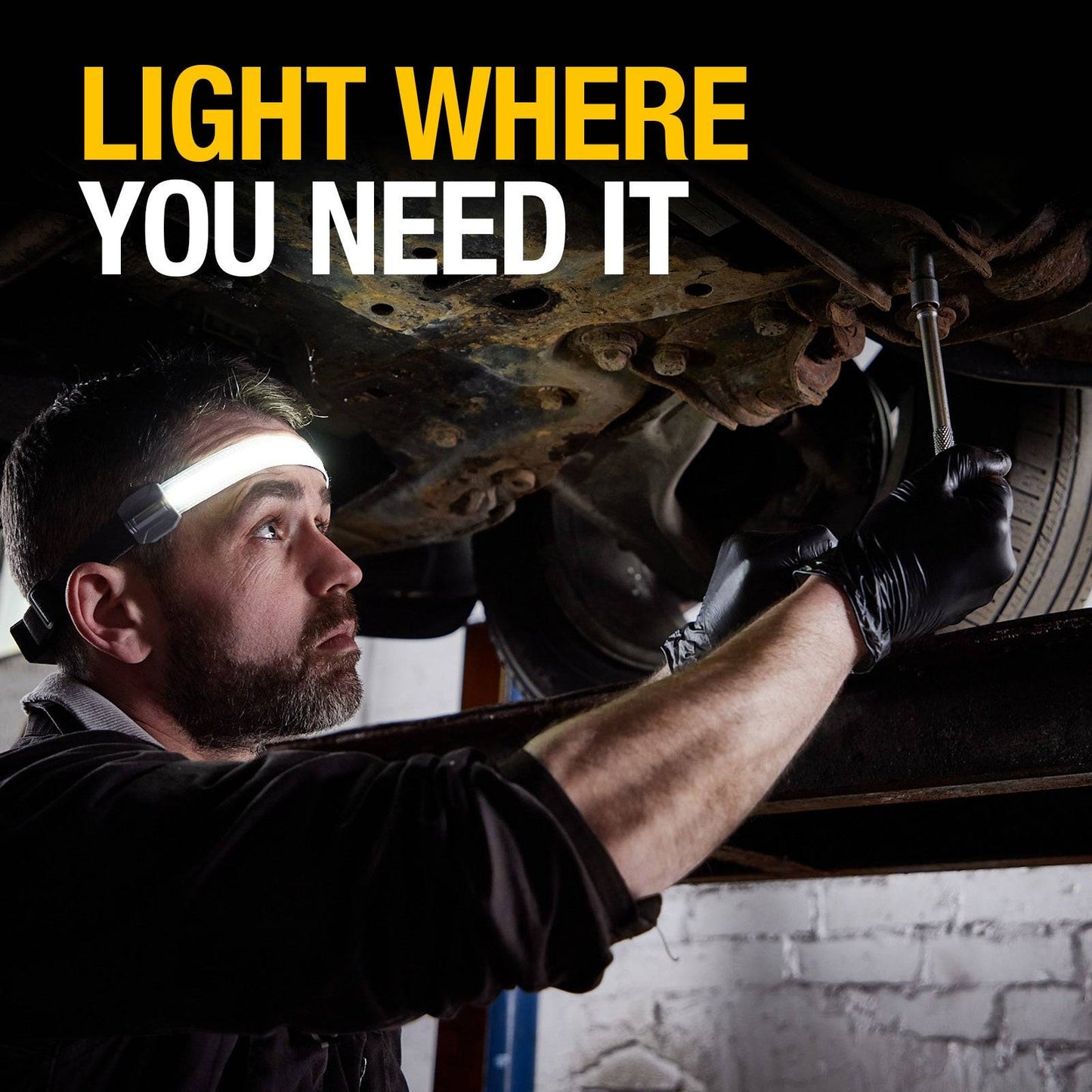 Mechanic using Flexible Head Torch RIL0115 under vehicle, providing targeted lighting for automotive repair in low-light conditions.