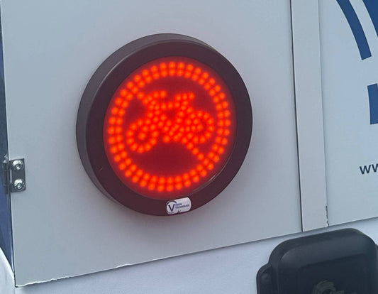 VT LED Cyclists Warning Turn Sign mounted on a vehicle, displaying a bright red illuminated bicycle symbol to alert nearby cyclists during turns.