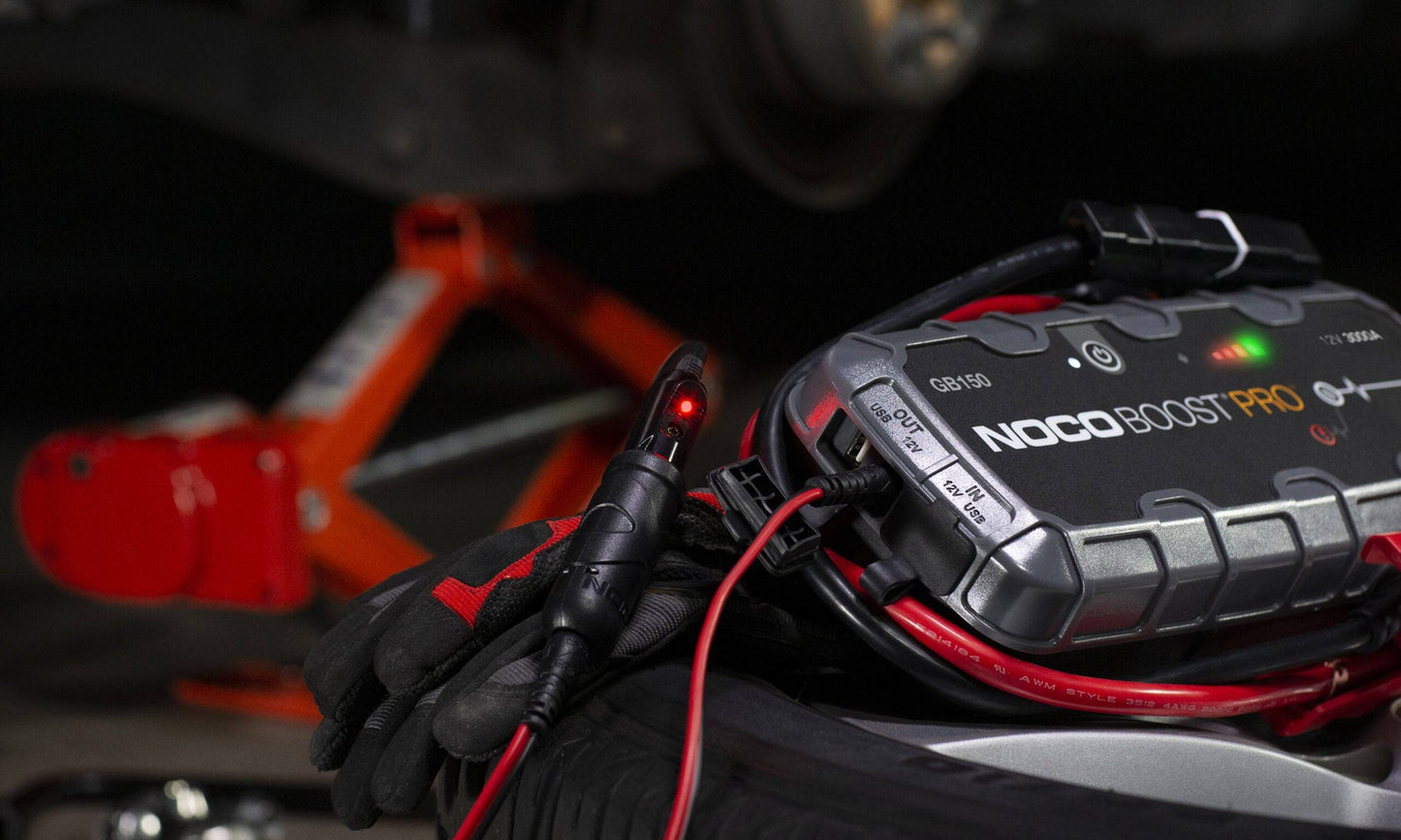 Noco GB150 Boost Pro 12V 3000A Jump Starter Lithium Jump Starter connected to vehicle battery with heavy duty clamps.